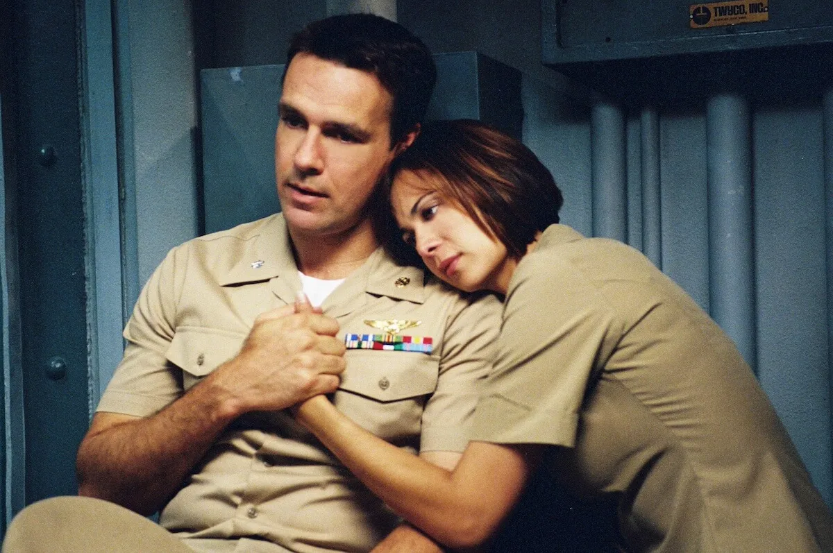 Catherine Bell with her arms around David James Elliott in 'JAG'