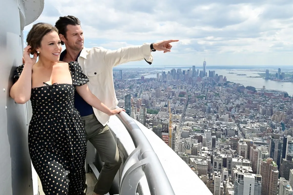 Erin Krakow and Kevin McGarry looking at the Manhattan skyline on the Empire State Building outdoor observation deck