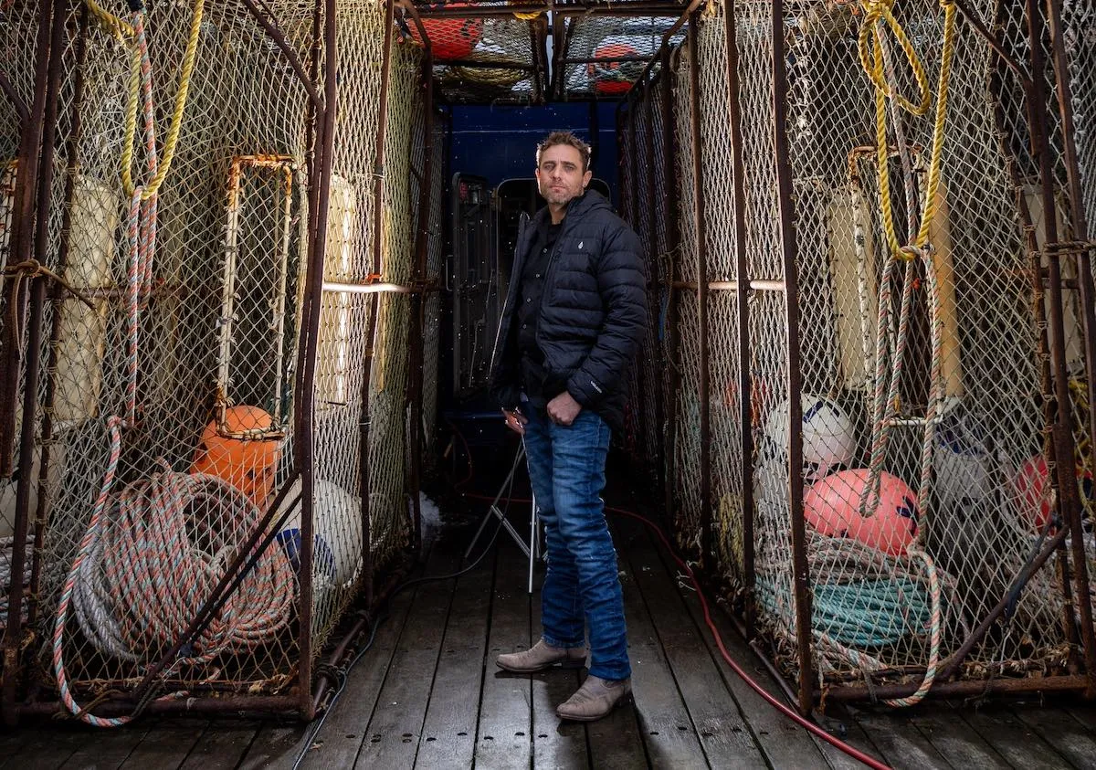 Jake Anderson of 'Deadliest Catch' standing on the deck of a fishing boat