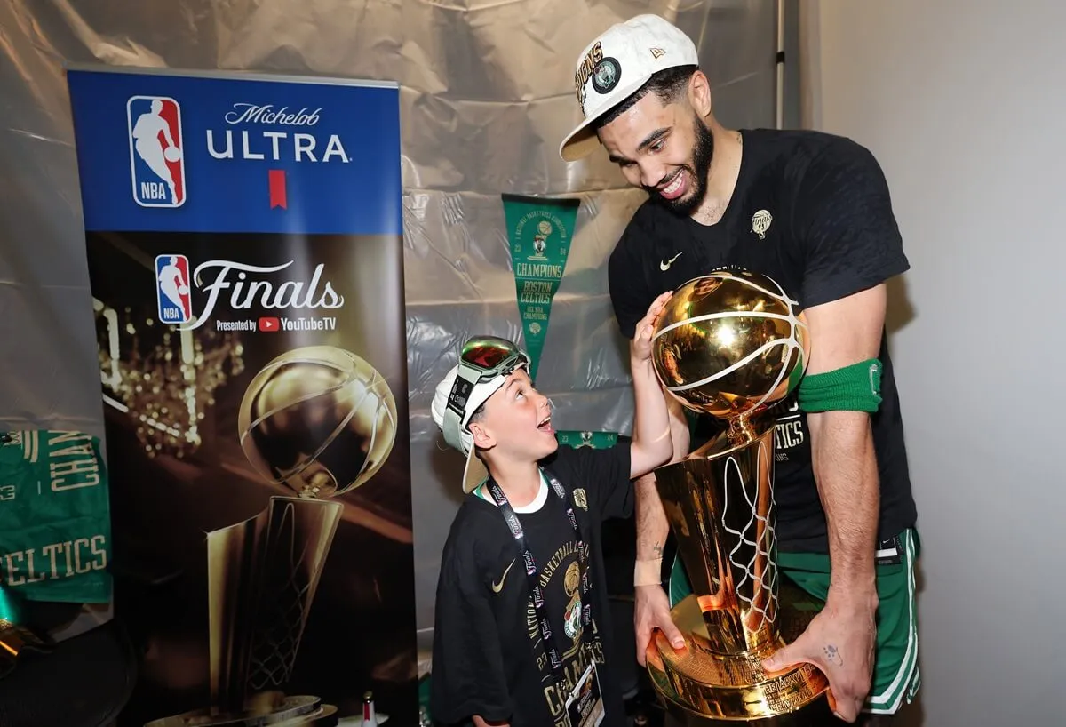Jayson Tatum of the Boston Celtics holds the Larry O’Brien Championship Trophy with his son, Jayson Christopher Tatum Jr. aka 'Deuce
