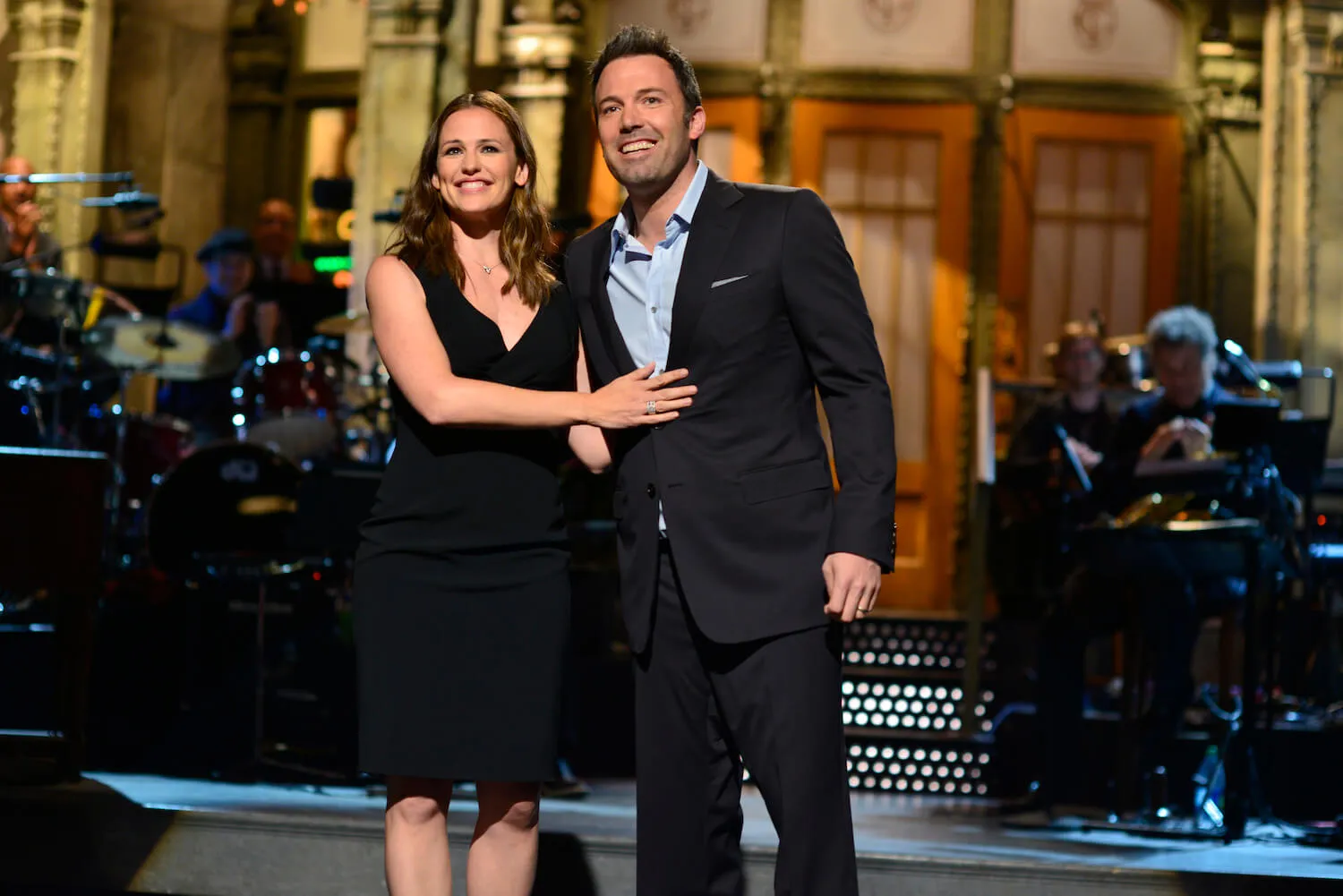 Jennifer Garner smiling and touching the front of Ben Affleck on the stage of 'SNL' in 2013
