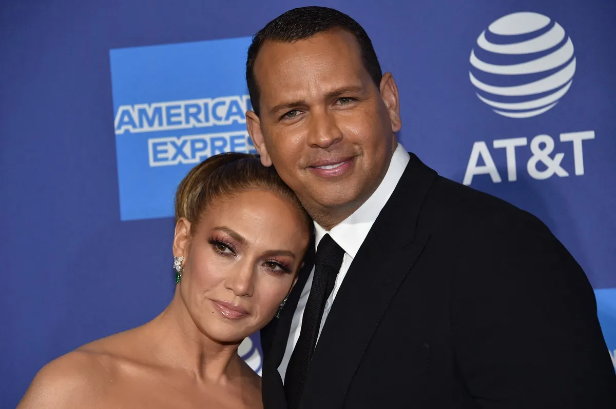 Jennifer Lopez and Alex Rodriguez arriving at the 31st Annual Palm Springs International Film Festival while wearing a suit and dress.