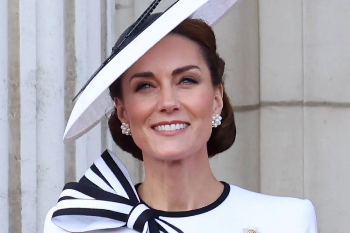 Kate Middleton, who sat down to watch the parade during Trooping the Colour 2024, looks on wearing a white hat and dress.