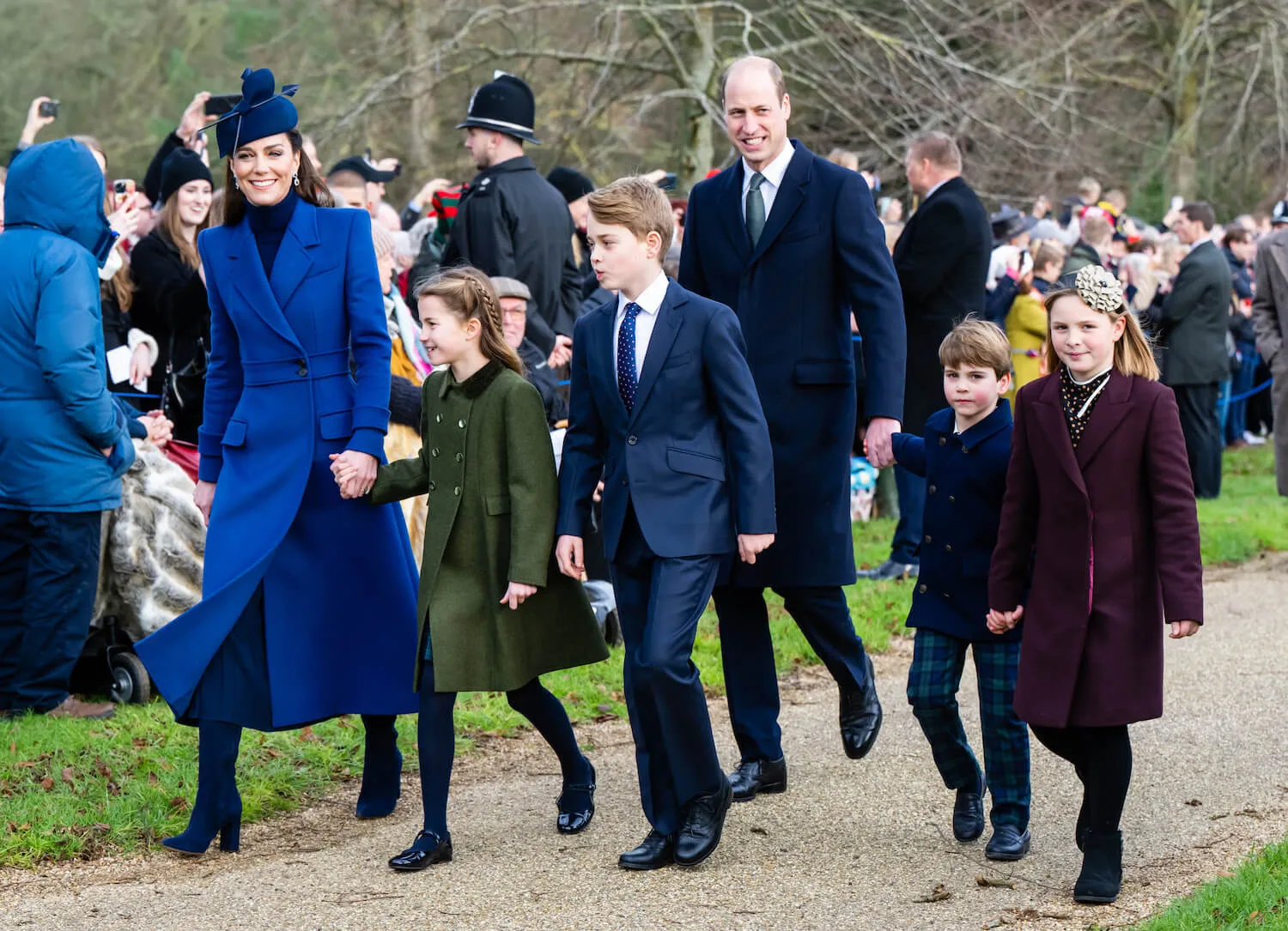 Kate Middleton walking and holding hands with Princess Charlotte while Prince William, Prince George, and Prince Louis walk beside and behind them