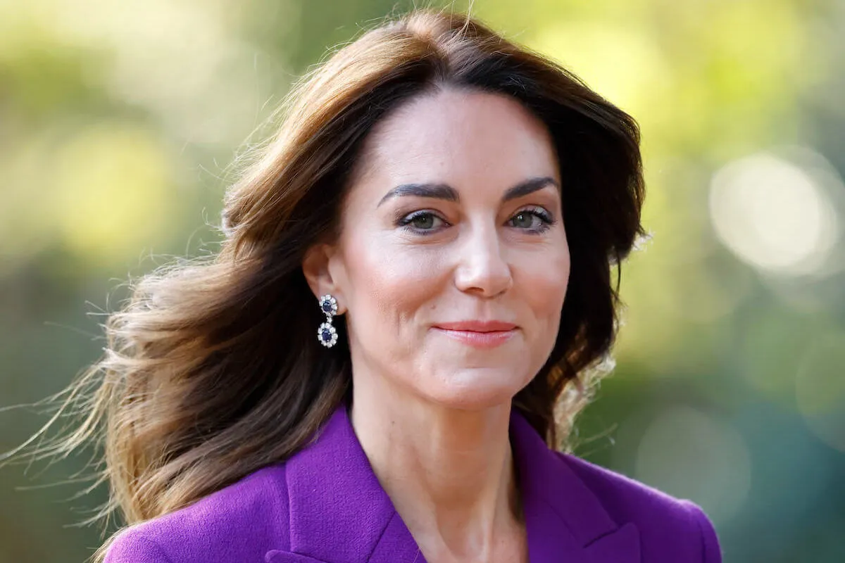 Kate Middleton, who will likely focus on her early childhood work for the rest of 2024, looks on wearing a purple pantsuit.