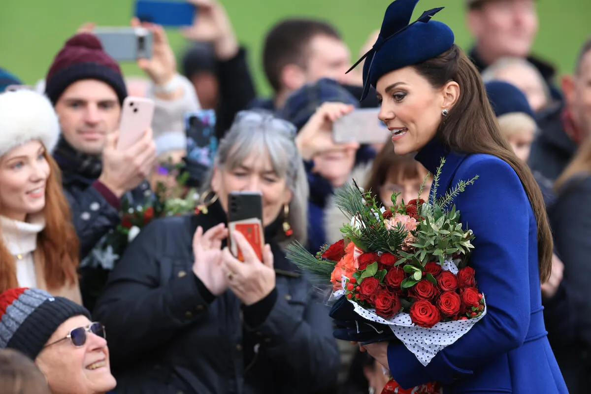 Kate Middleton, who will reportedly film a video before returning to work and public life, on Christmas Day 2023 holding flowers. 