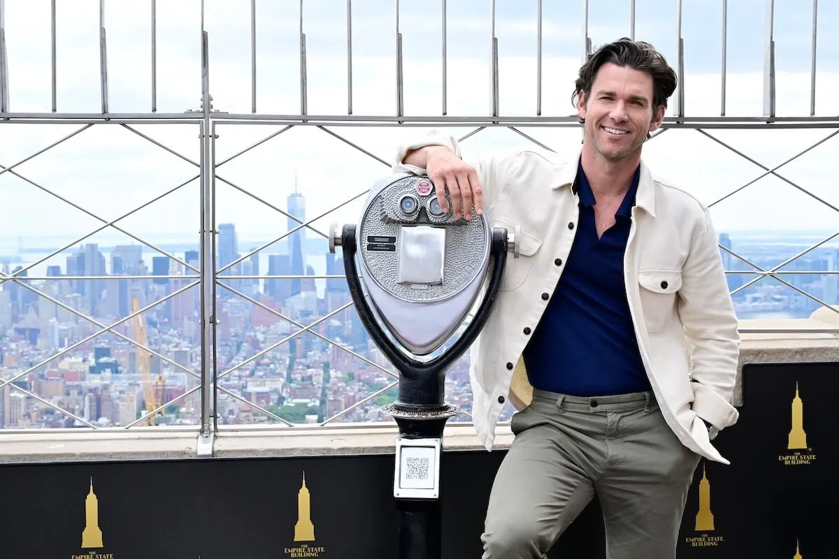 Kevin McGarry standing next to a scenic viewer on the Empire State Building outdoor observation deck