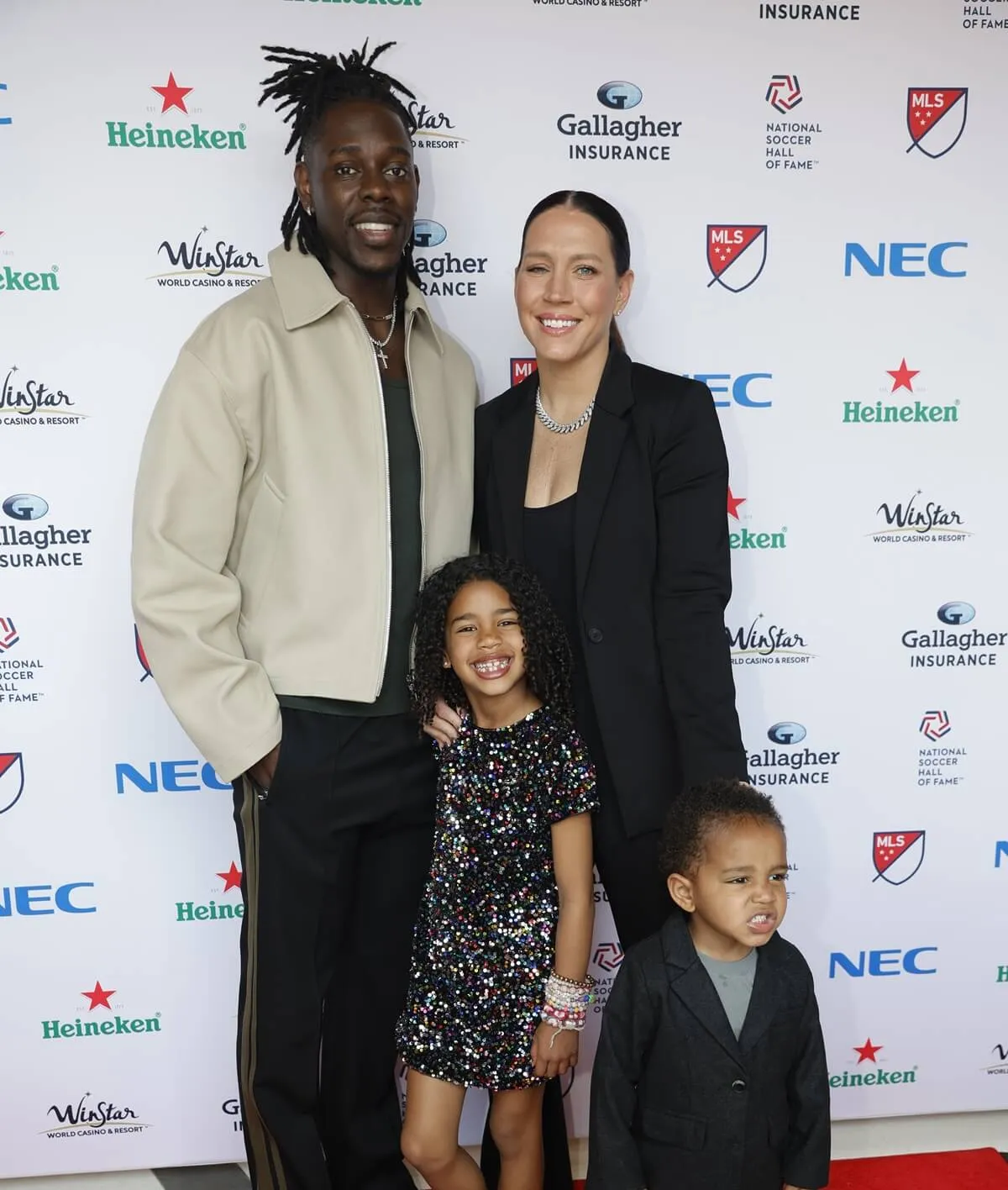 Lauren Holiday and Jrue Holiday pose on the red carpet with their kids at Toyota Stadium in Frisco, Texas