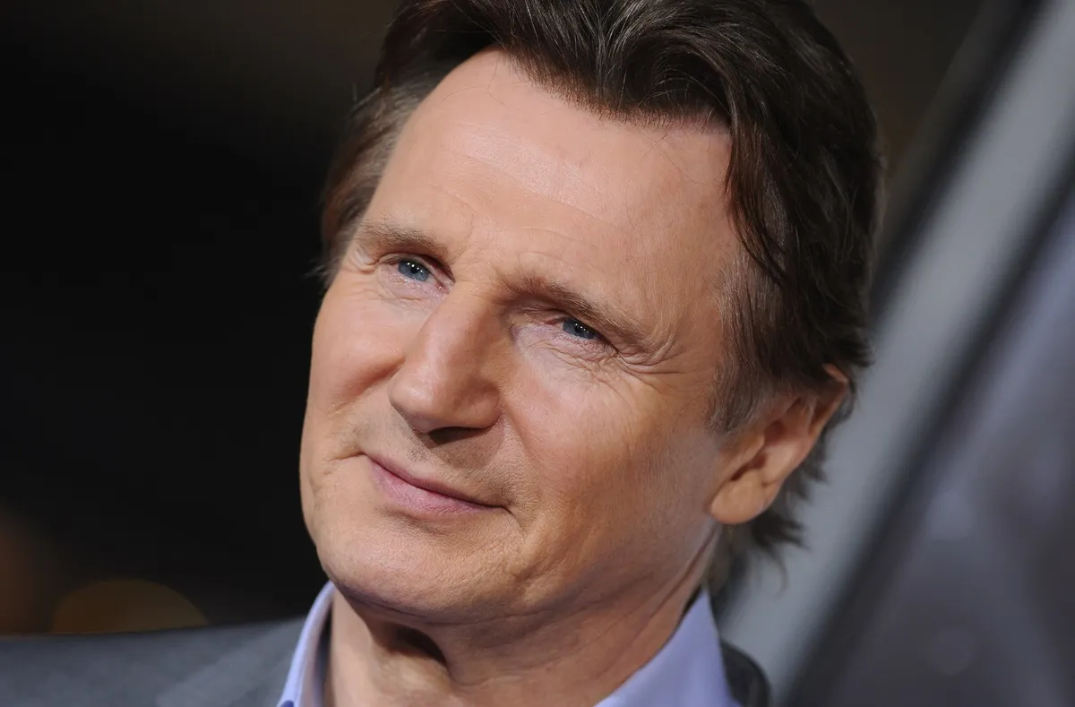 Liam Neeson posing in a suit at the Los Angeles premiere of 'Non-Stop' at Regency Village Theatre.
