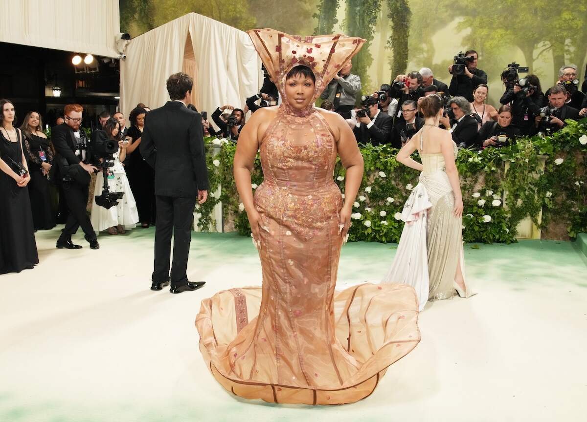 Singer Lizzo wears a mesh beige dress and headpiece to the 2024 Met Gala