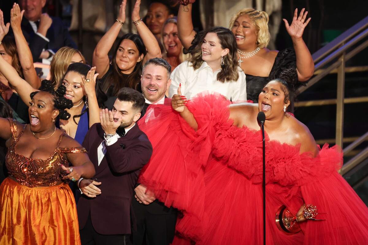 Singer Lizzo (R) accepts the award for Outstanding Competition Program while wearing a red dress