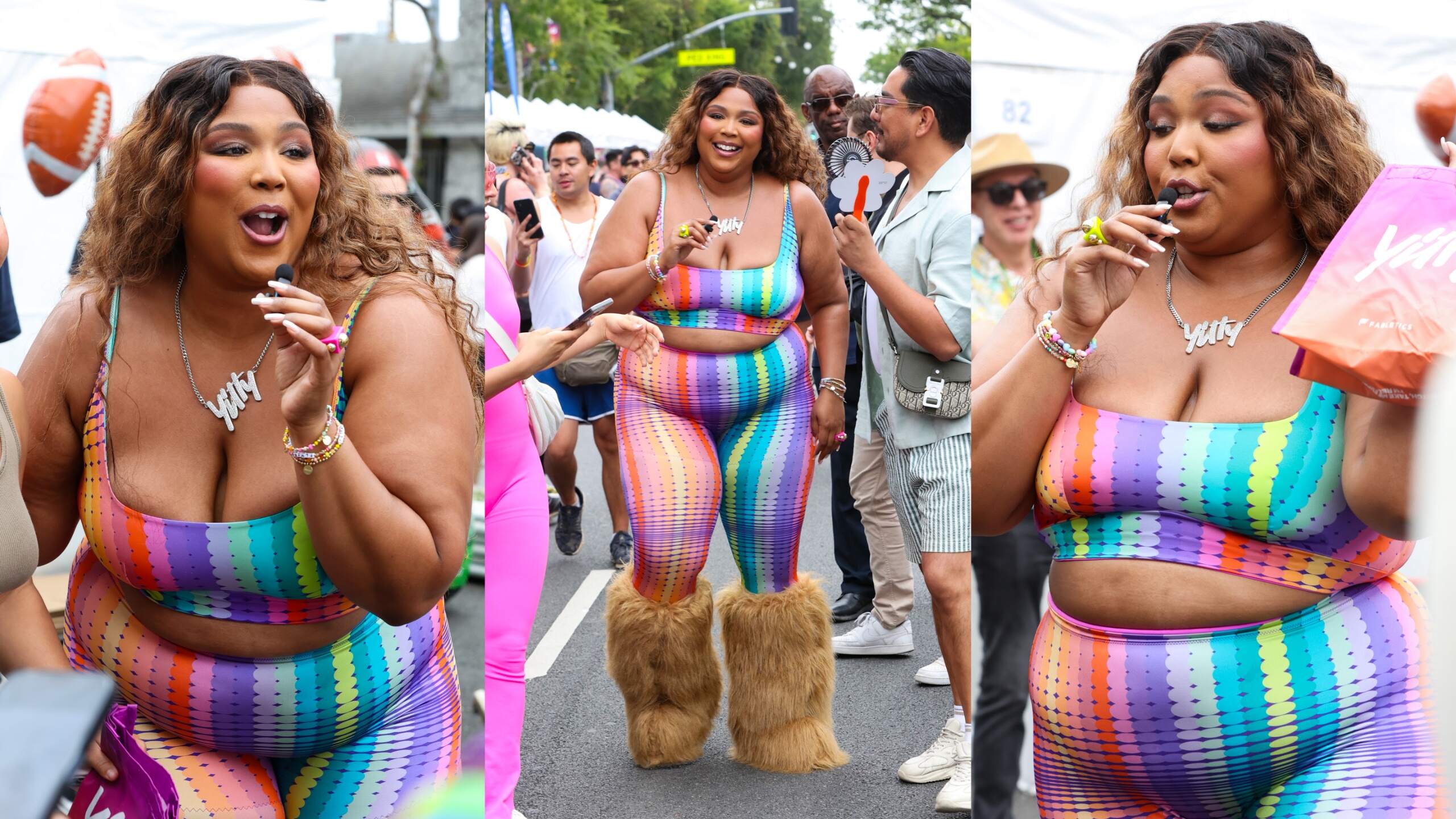 Singer Lizzo speaks into a tiny microphone while wearing a rainbow top at a Pride Parade