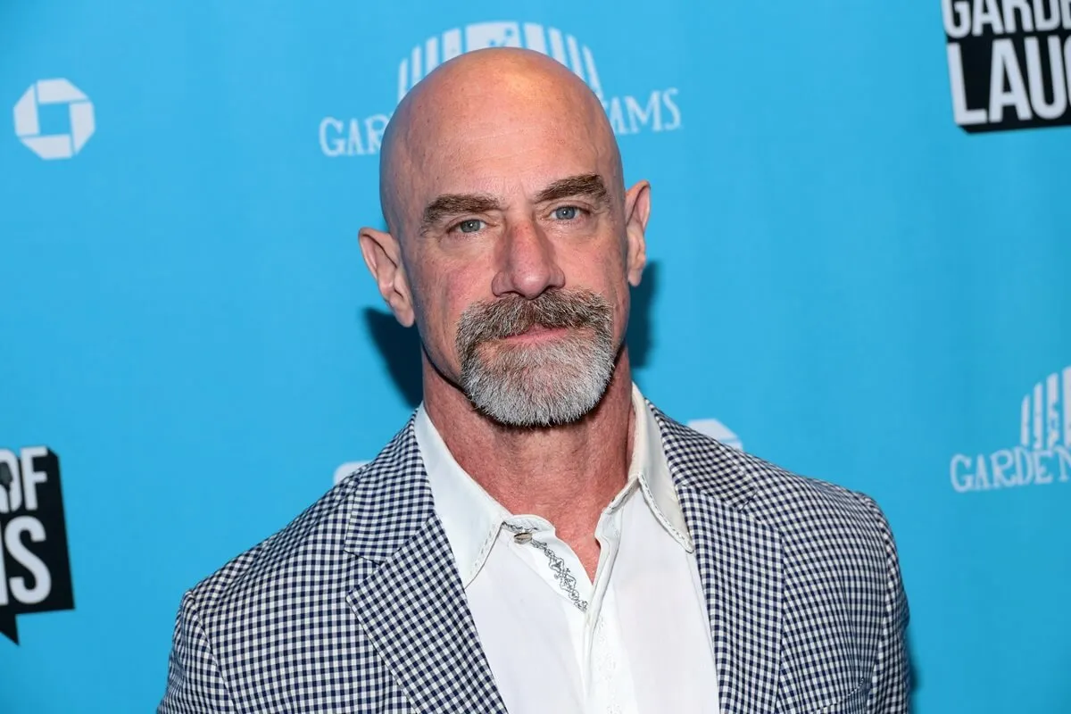Chris Meloni attending the 2024 Garden Of Laughs Comedy Benefit at Madison Square Garden while wearing a grey and white suit.