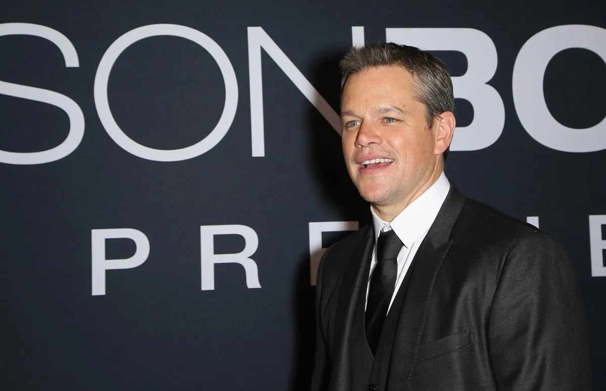 Matt Damon posing in a black suit at the premiere of 'Jason Bourne'.