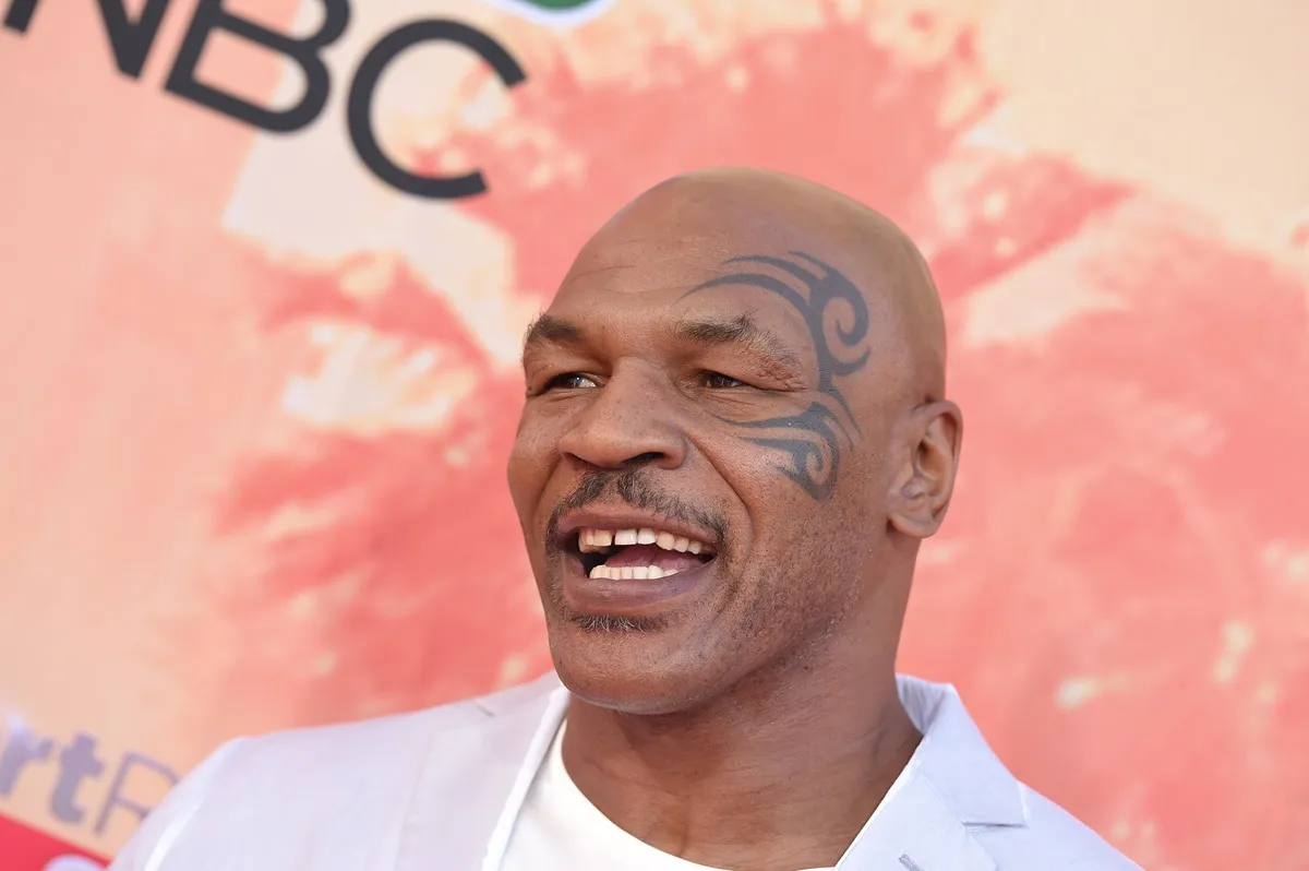 Mike Tyson arriving at the at the 2015 iHeartRadio Music Awards wearing a light blue suit.