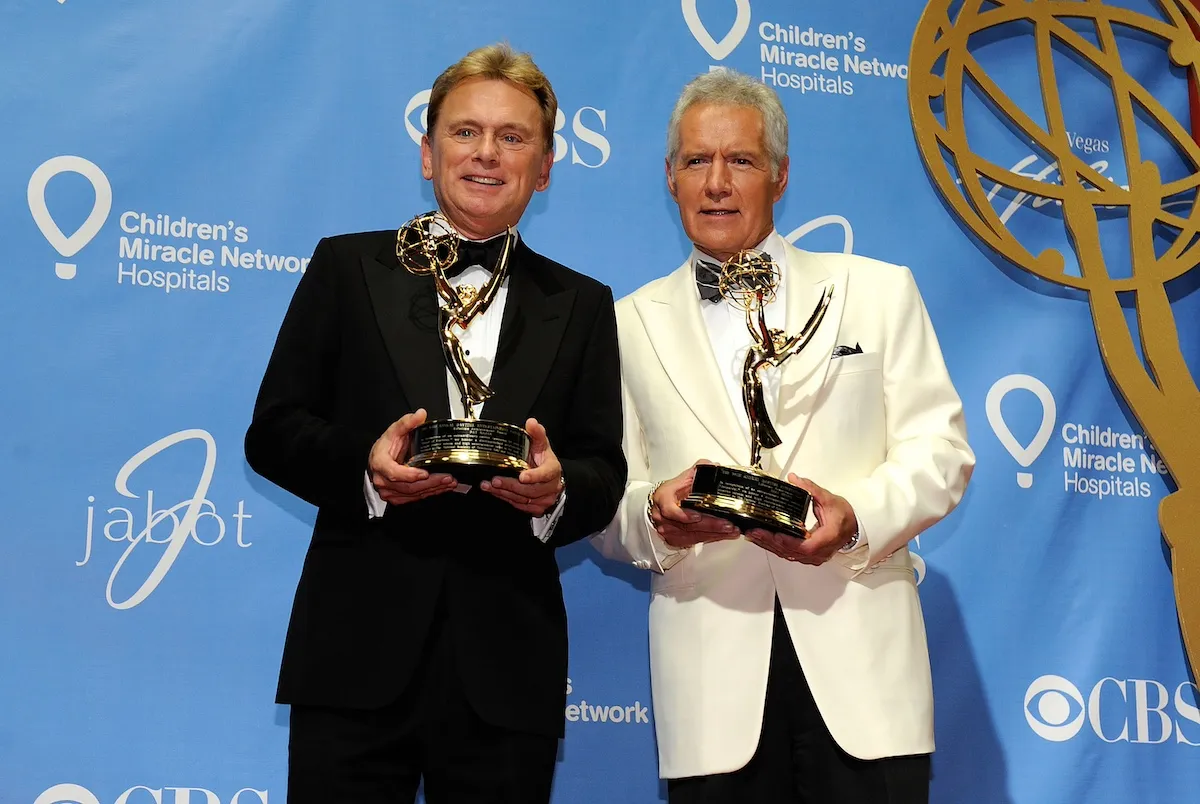 Pat Sajak and Alex Trebek holding their Emmy Award statuettes