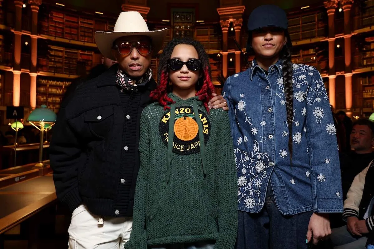 Family membres Pharrell Williams, Rocket Williams and Helen Lasichanh stand together before a Kenzo show in 2023