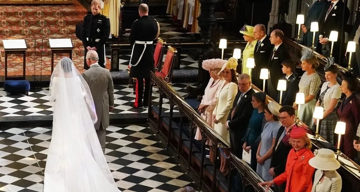 Prince Harry looks at his bride, Meghan Markle, as she walks up the aisle accompanied by then-Prince Charles