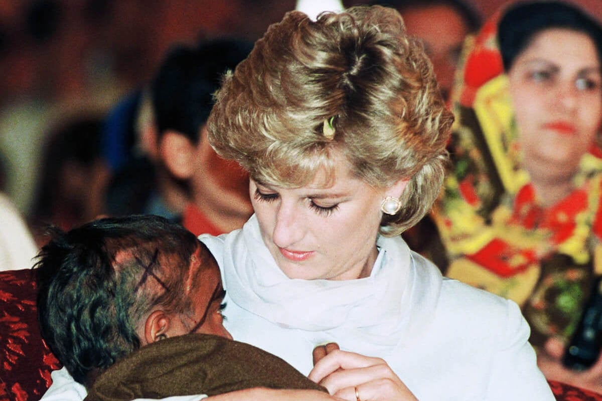 Princess Diana holds a boy in her arms in one of her 'favorite' photographs of herself taken by Anwar Hussein