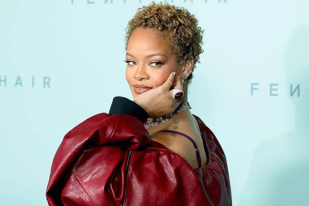 Rihanna turns away from the camera and poses to show off her ruby ring