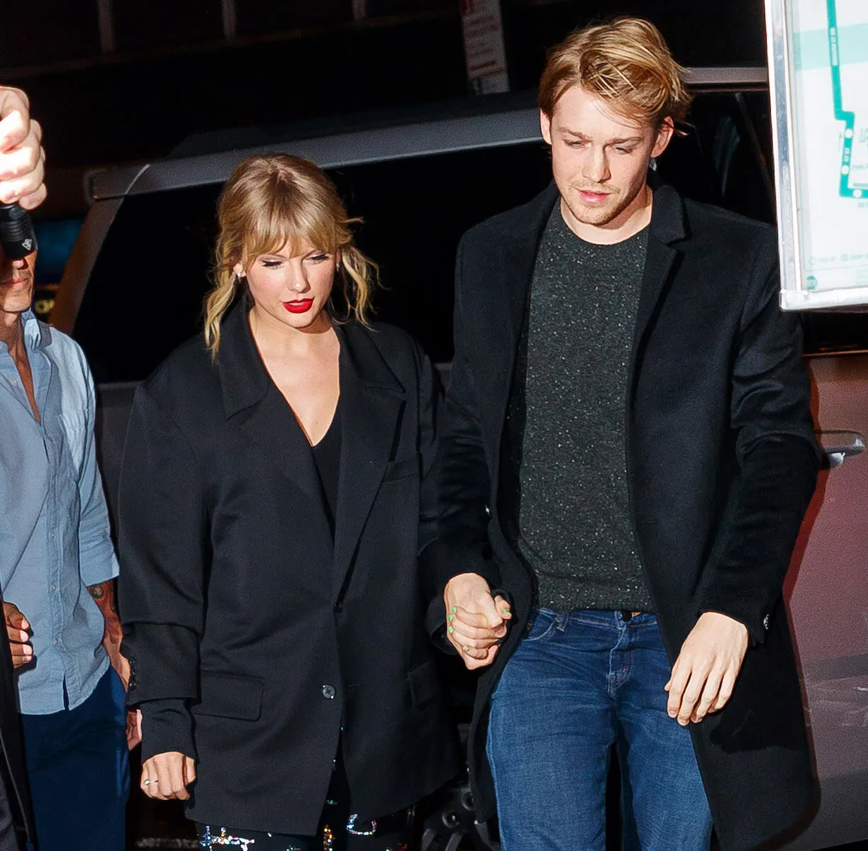 Taylor Swift and Joe Alwyn holding hands and walking at night in 2019