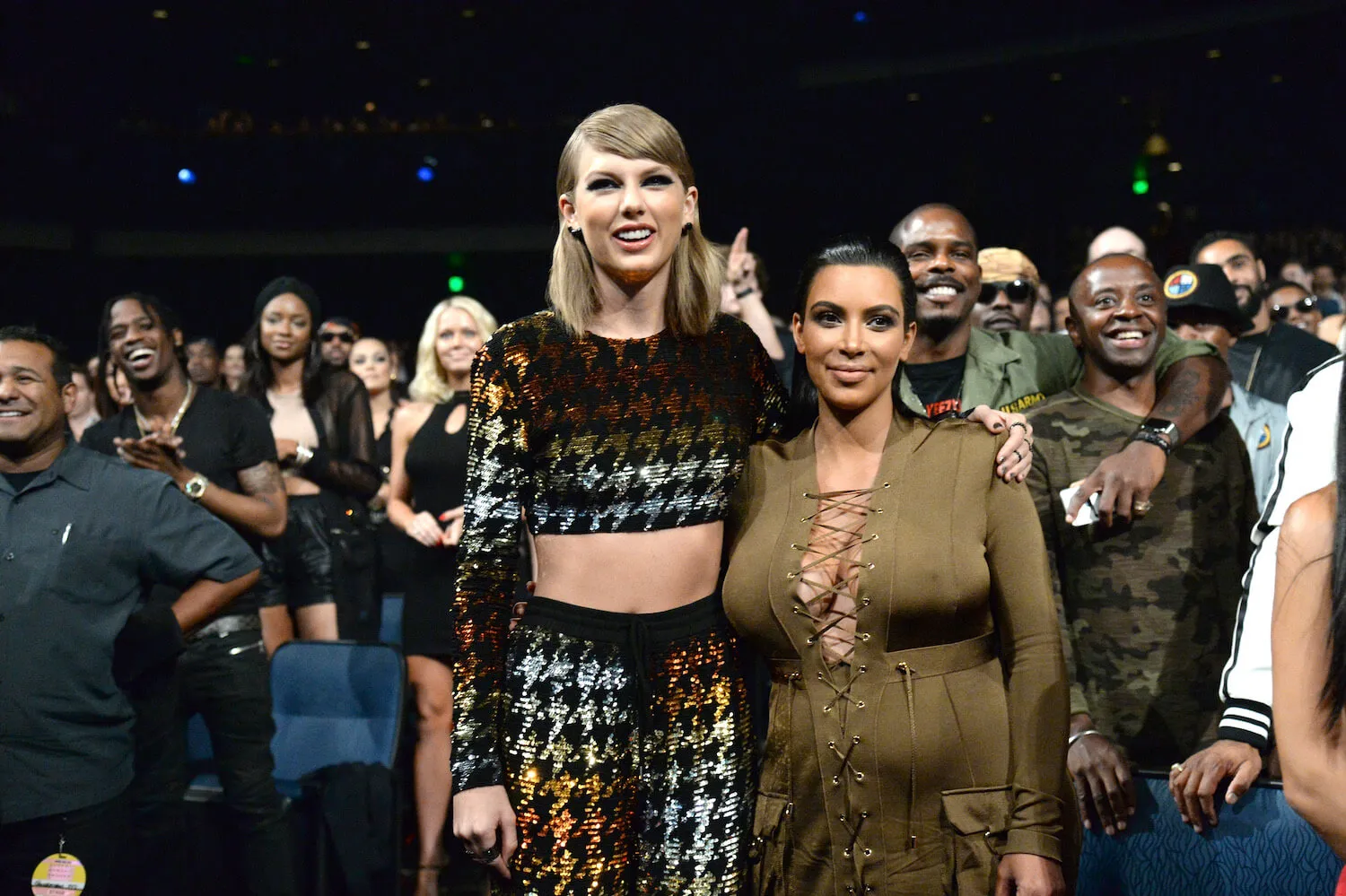 Taylor Swift and Kim Kardashian smiling and standing next to each other with their arms around each other at the 2015 MTV Video Music Awards