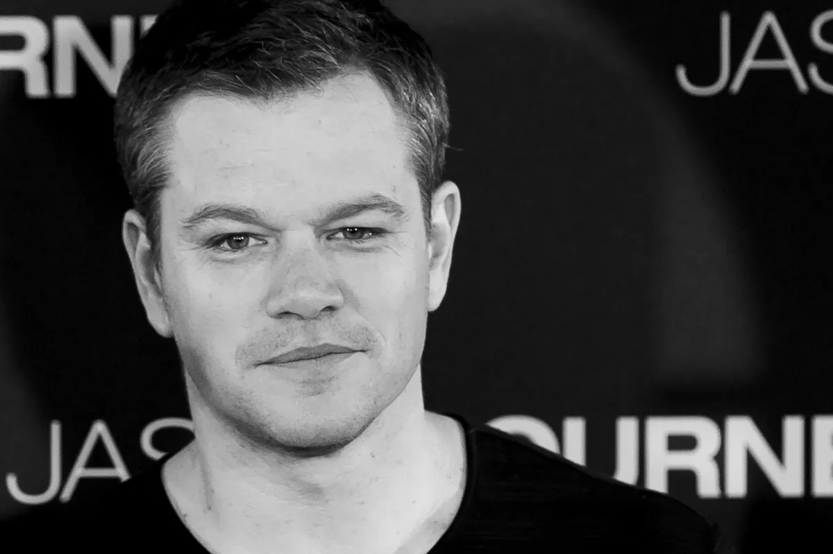 Matt Damon posing in a black shirt at a photocall for 'The Bourne Legacy'.