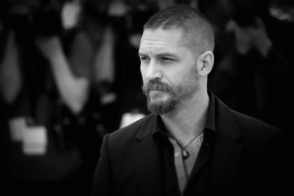 Tom Hardy posing in a black suit at the premiere of 'Mad Max Fury Road'.