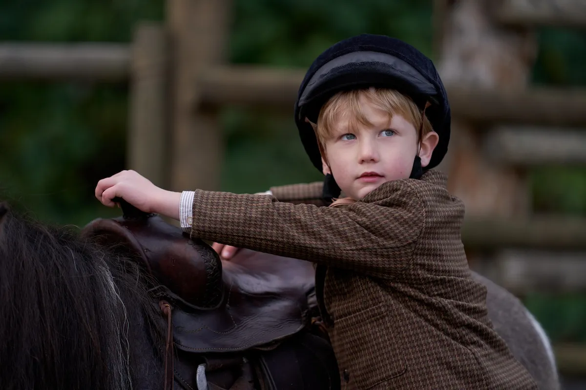Little Jack standing next to his pony on 'When Calls the Heart'