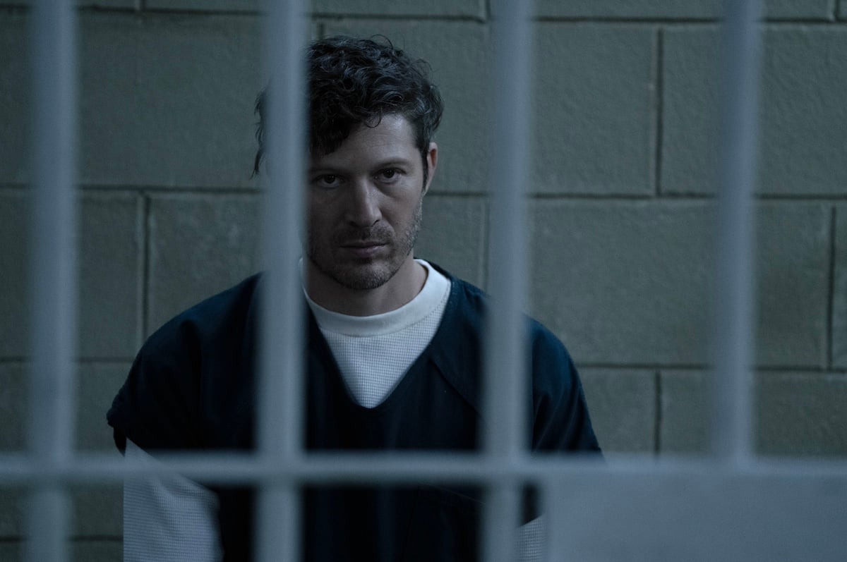 Zach Gilford as Elias Voit in a prison cell with cinderblock walls in 'Criminal Minds: Evolution' Season 2