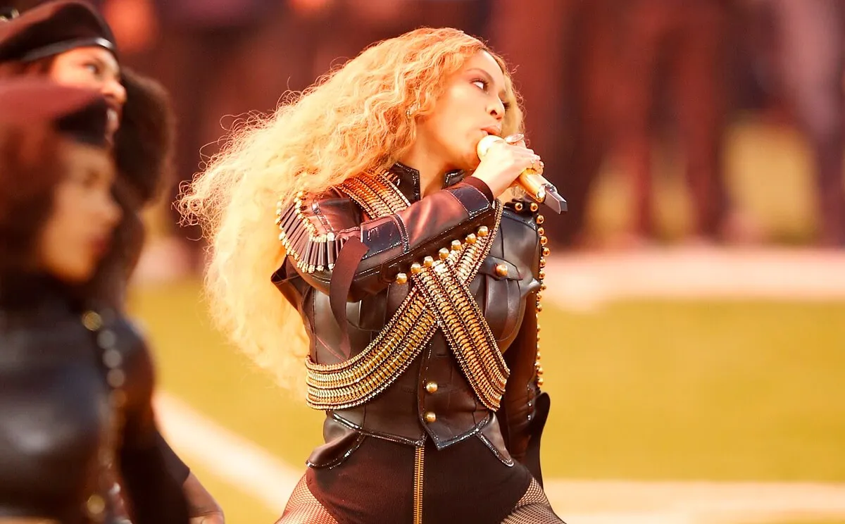 Beyonce singing during the Pepsi Super Bowl 50 Halftime Show in a black outfit.
