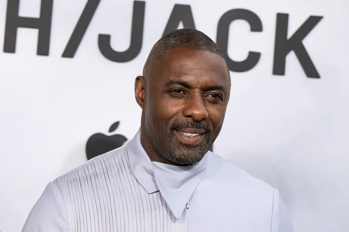 Idris Elba posing in a light blue outfit at the premiere of the movie 'Hijack'.