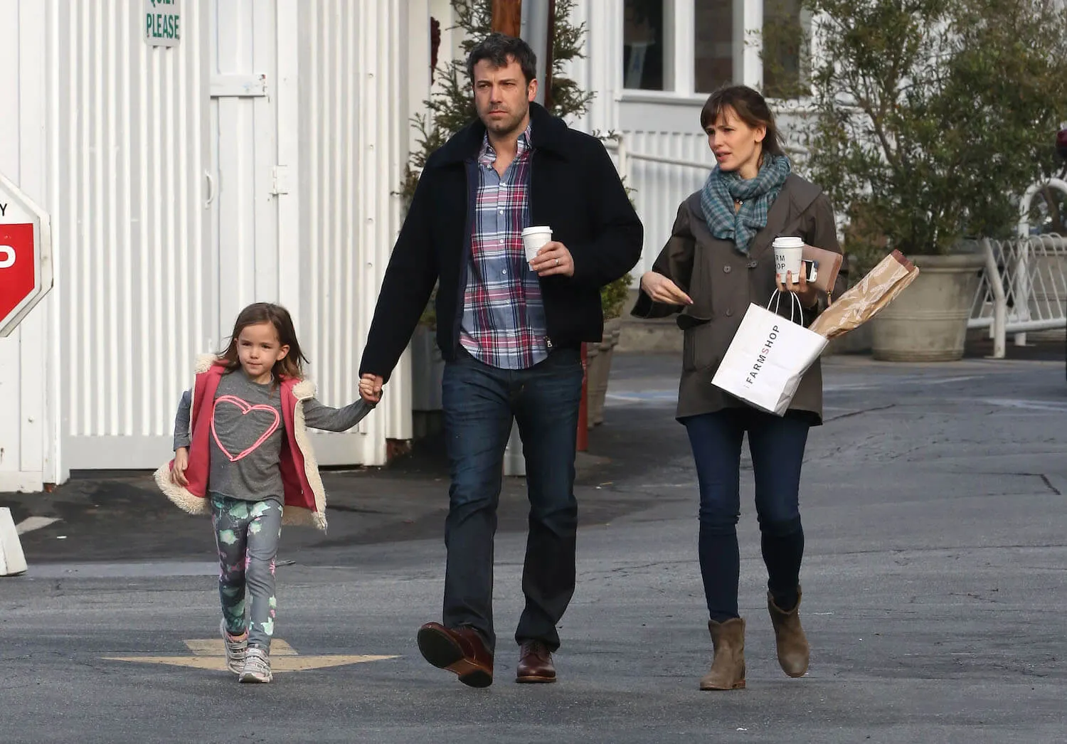 Ben Affleck holding hands with his young daughter, Seraphina, with Jennifer Garner walking behind them in 2014