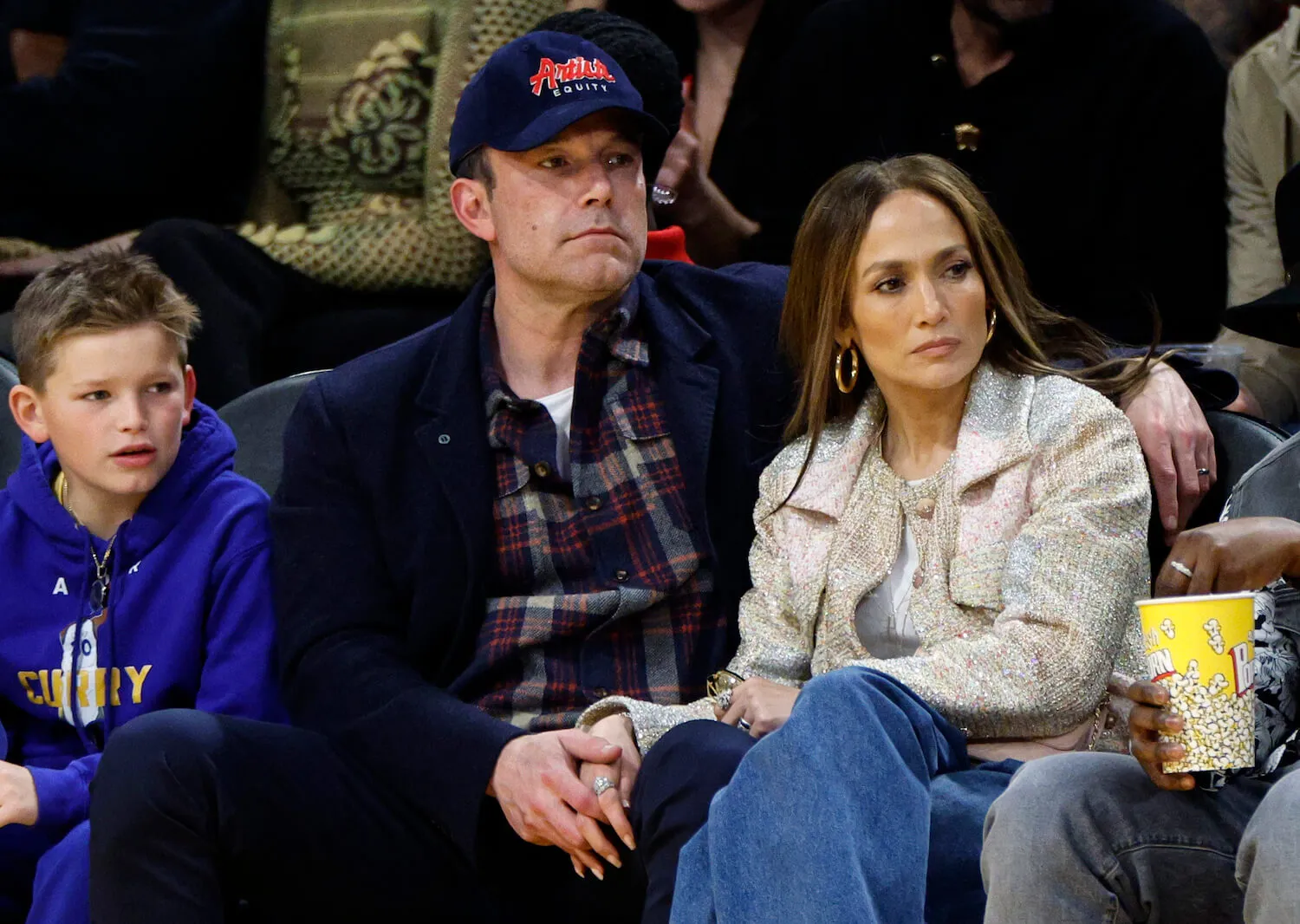 Ben Affleck holding hands with Jennifer Lopez while they sit and attend a basketball game with his son in March 2024