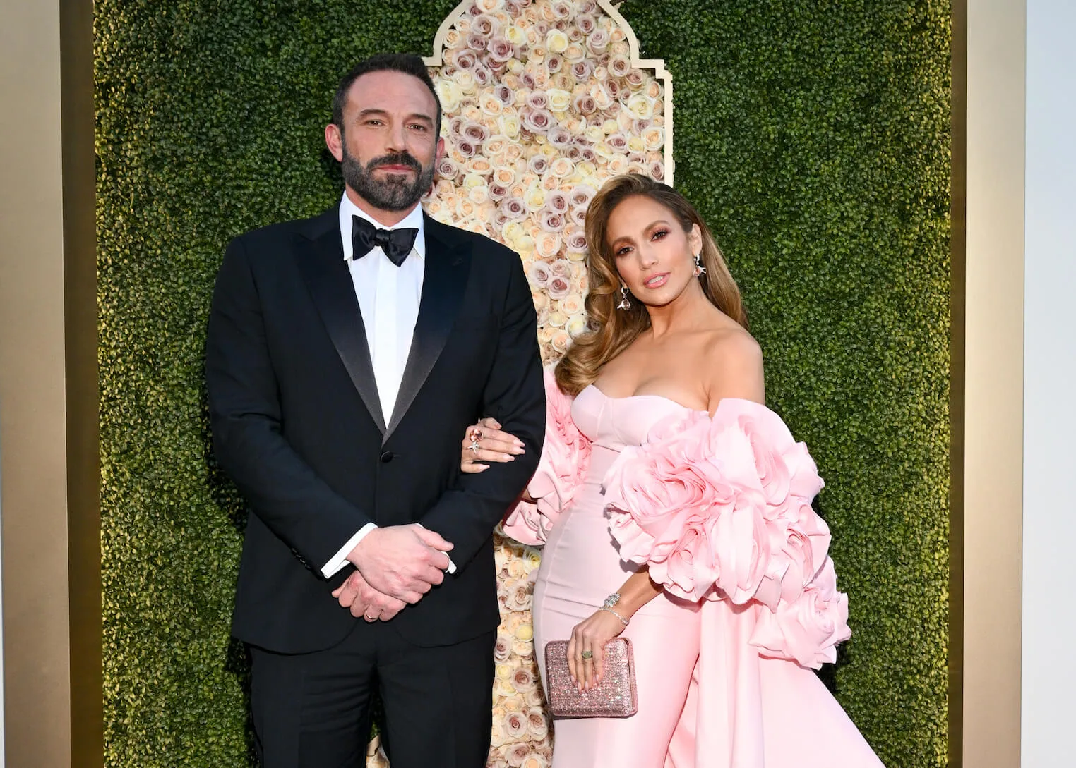 Ben Affleck in a tuxedo posing withJennifer Lopez in a pink dress at the 81st Golden Globes