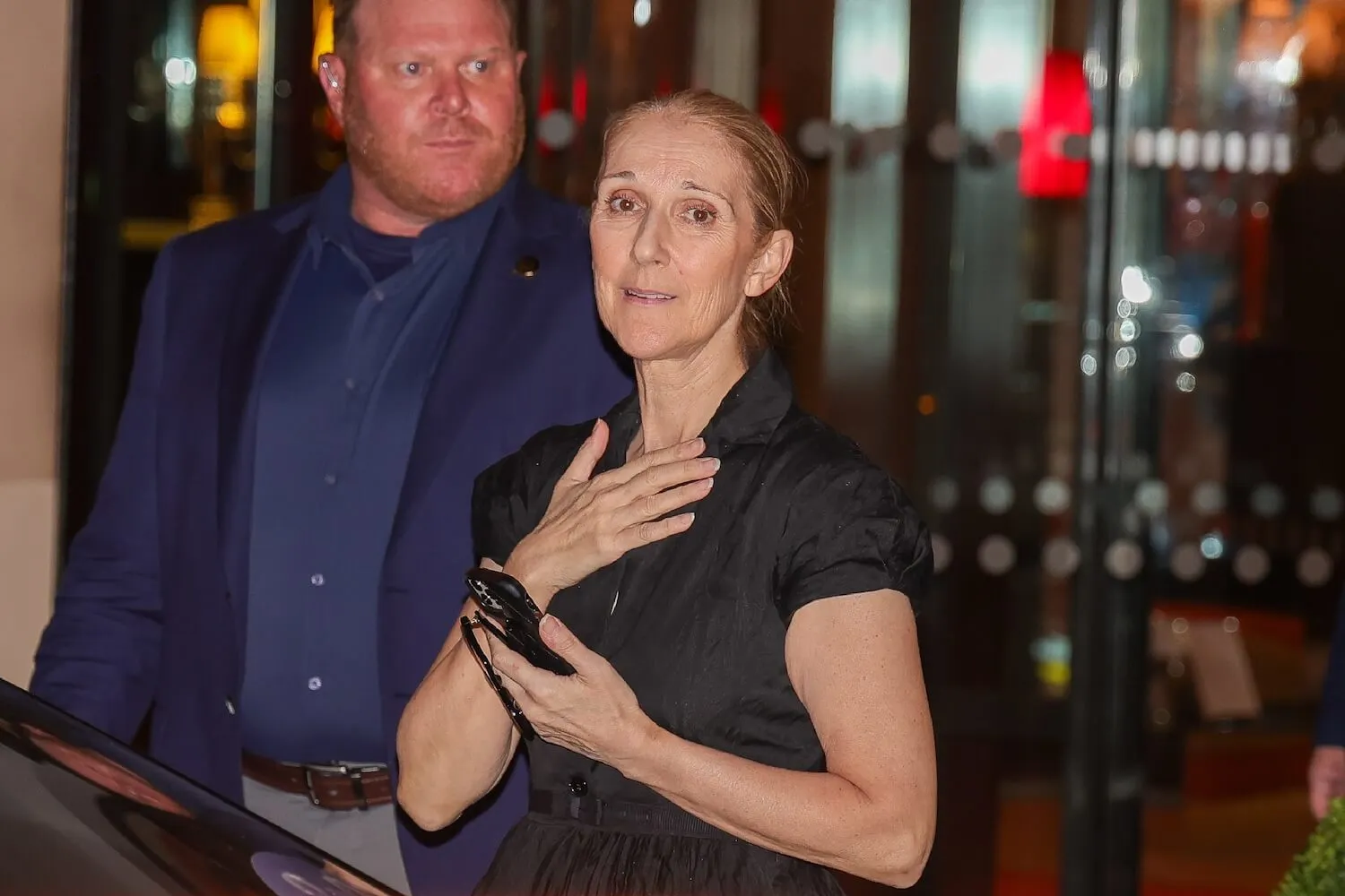 Céline Dion with her hand on her chest while wearing a black Dior dress in Paris, France, in 2024