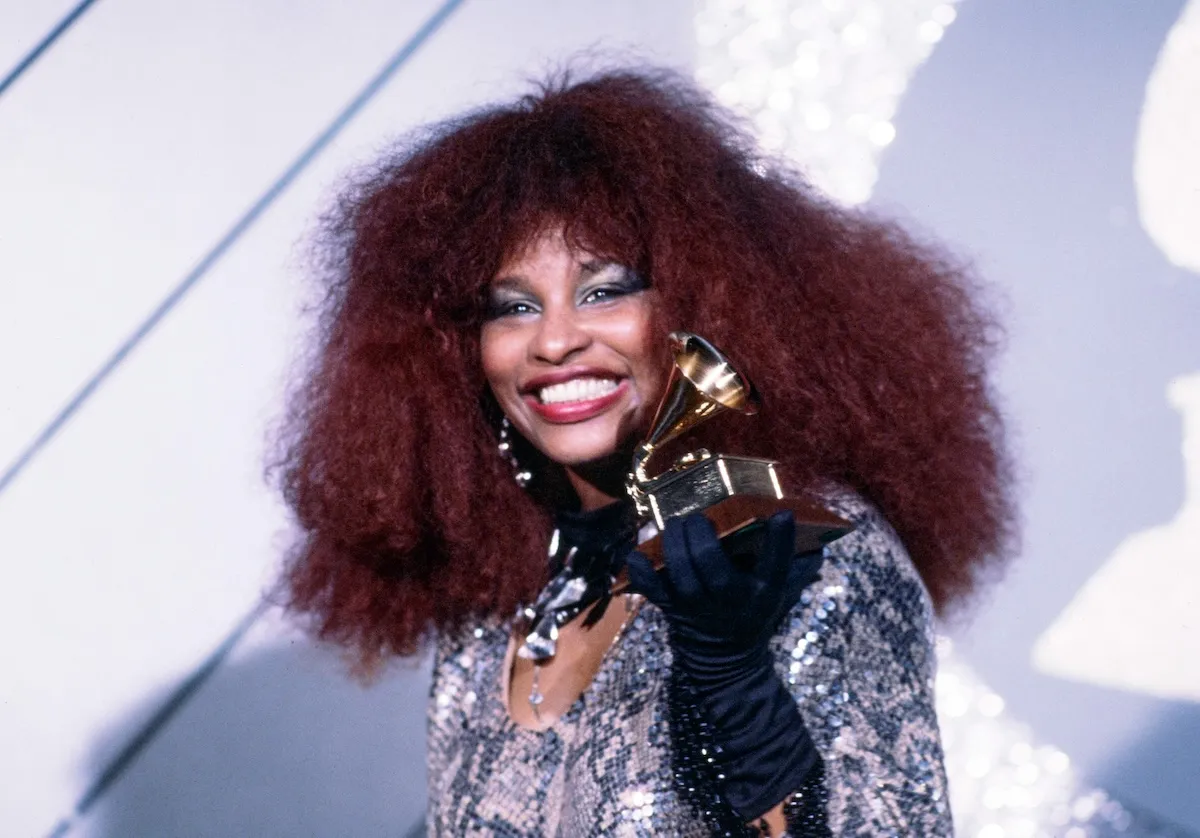 Wearing a silvery dress, Chaka Khan smiles with her Grammy Award in 1985