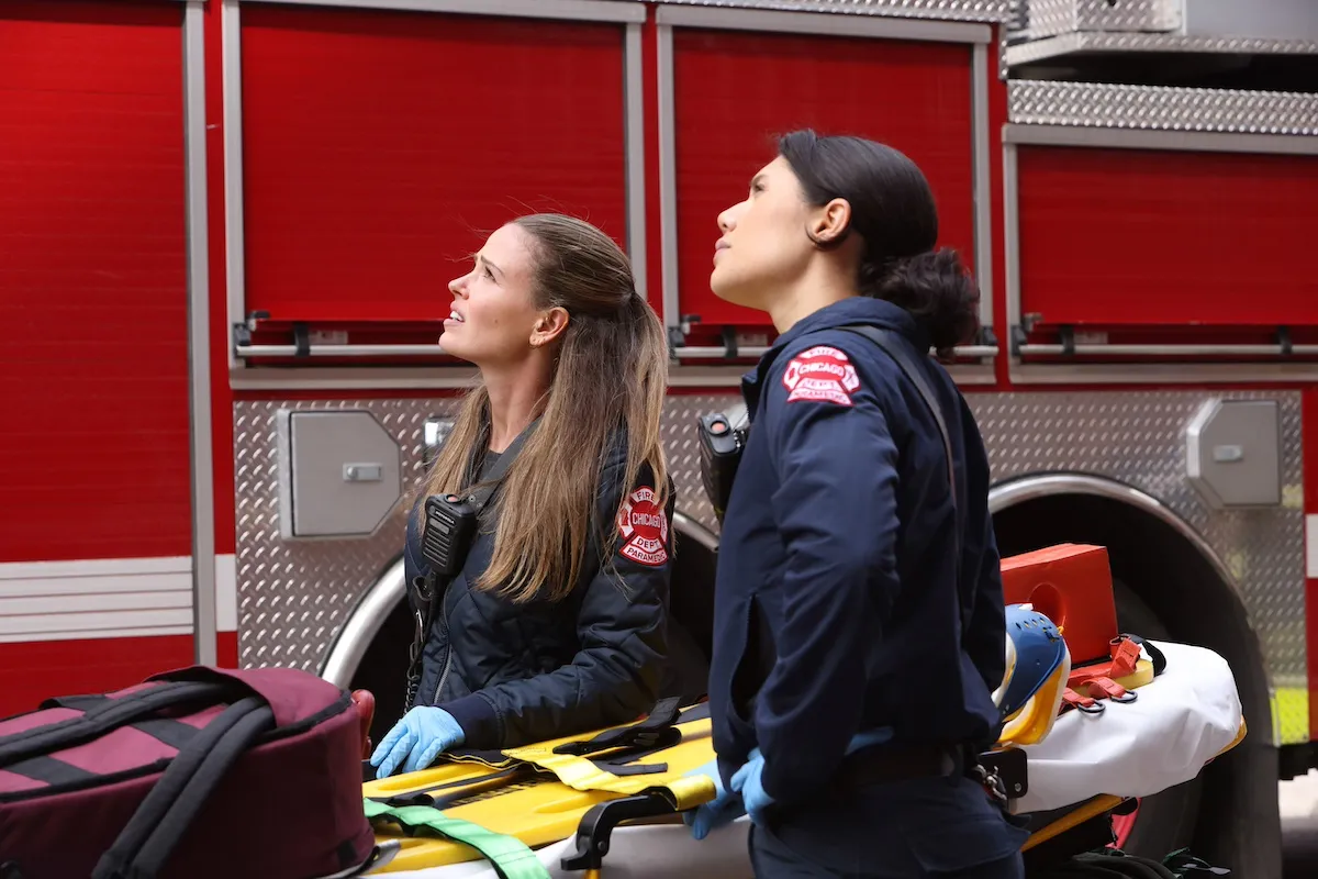Two female paramedics looking upward in 'Chicago Fire'