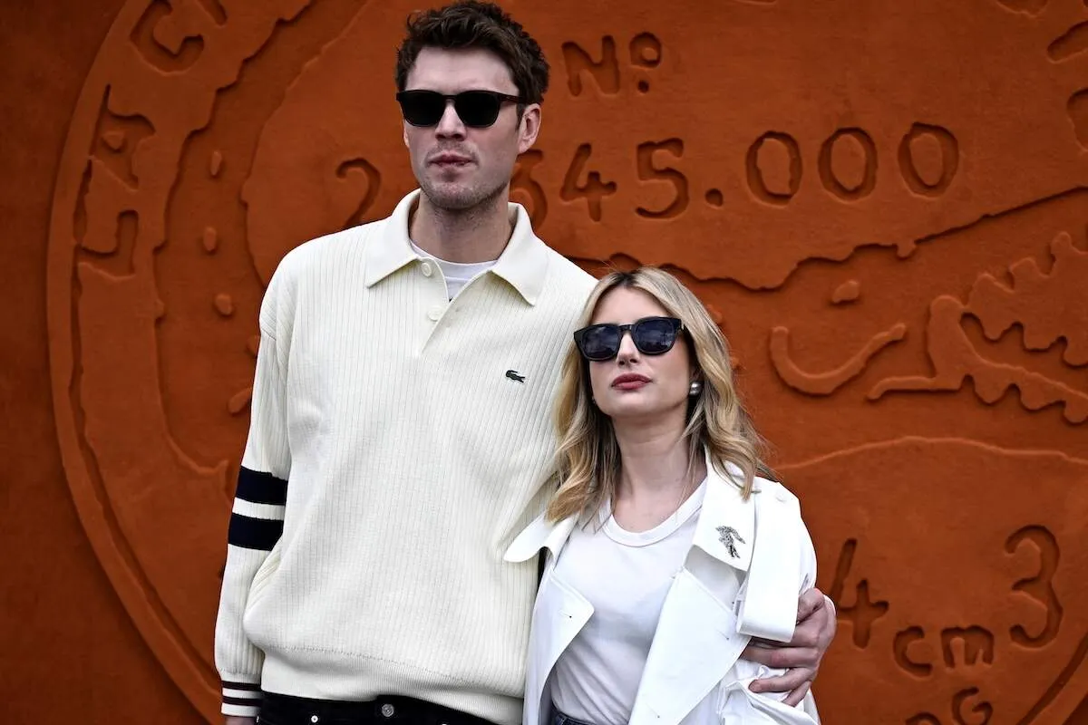 Cody John and Emma Roberts wear white as they pose for photos before a Lacoste runway show