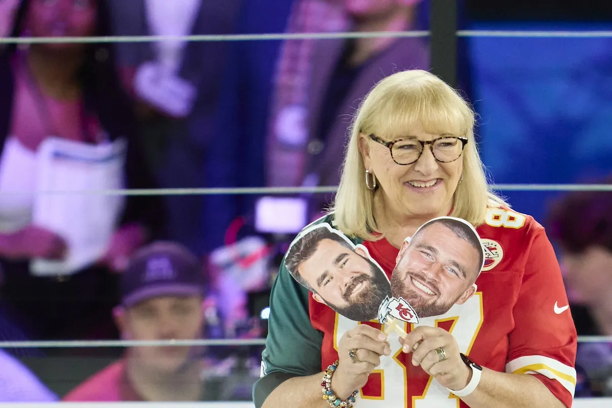 Donna Kelce holding photos of her sons, Travis Kelce and Jason Kelce