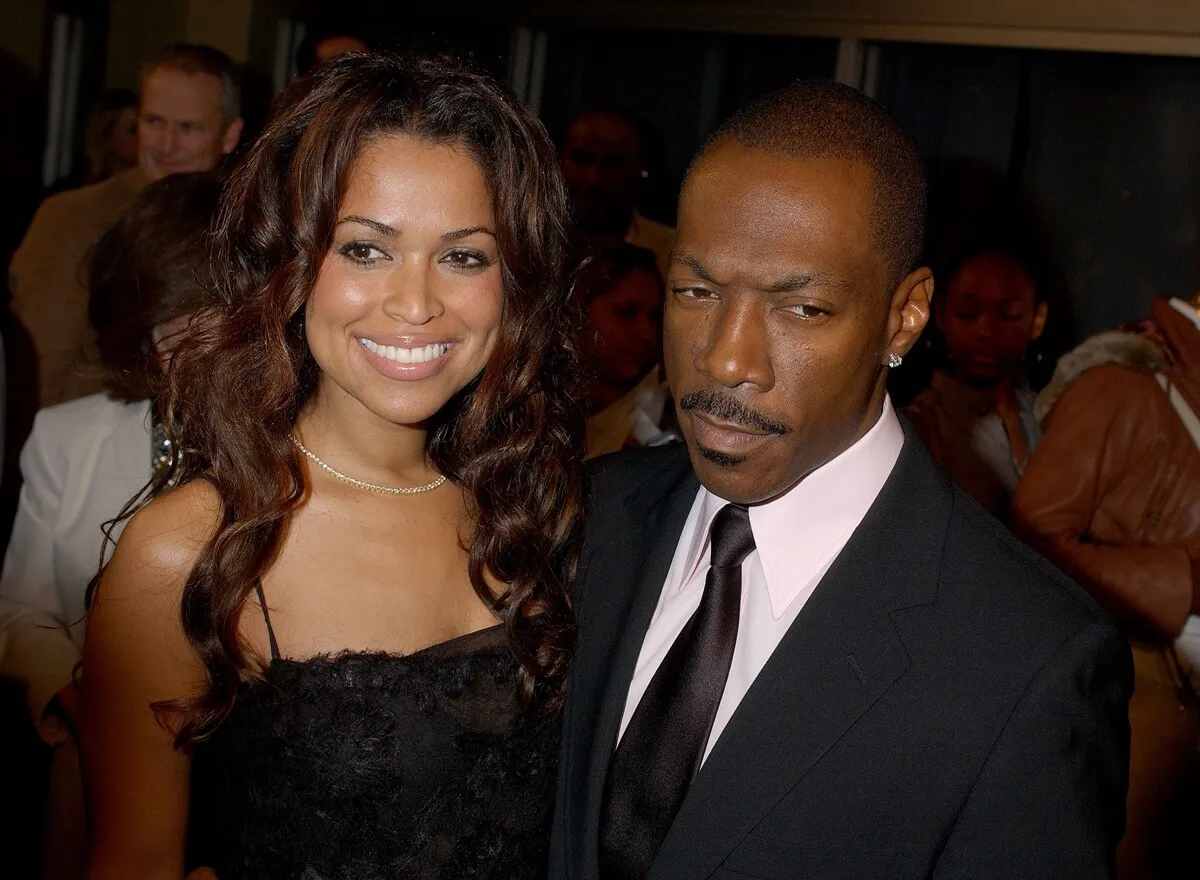 Eddie Murphy posing in a suit next to Tracey Edwards at the premiere of 'Dreamgirls'.