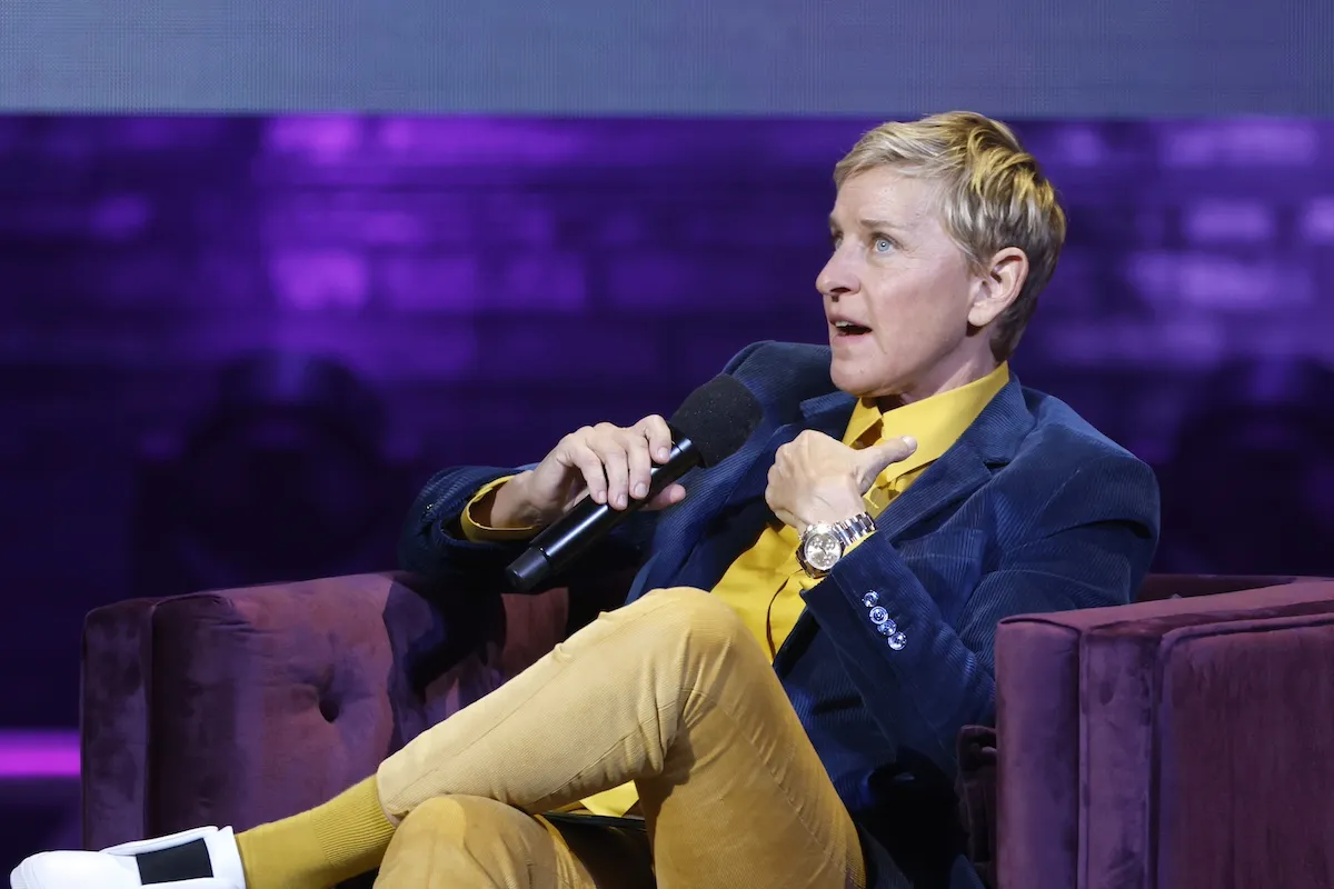 Ellen DeGeneres holding a microphone and sitting in a chair
