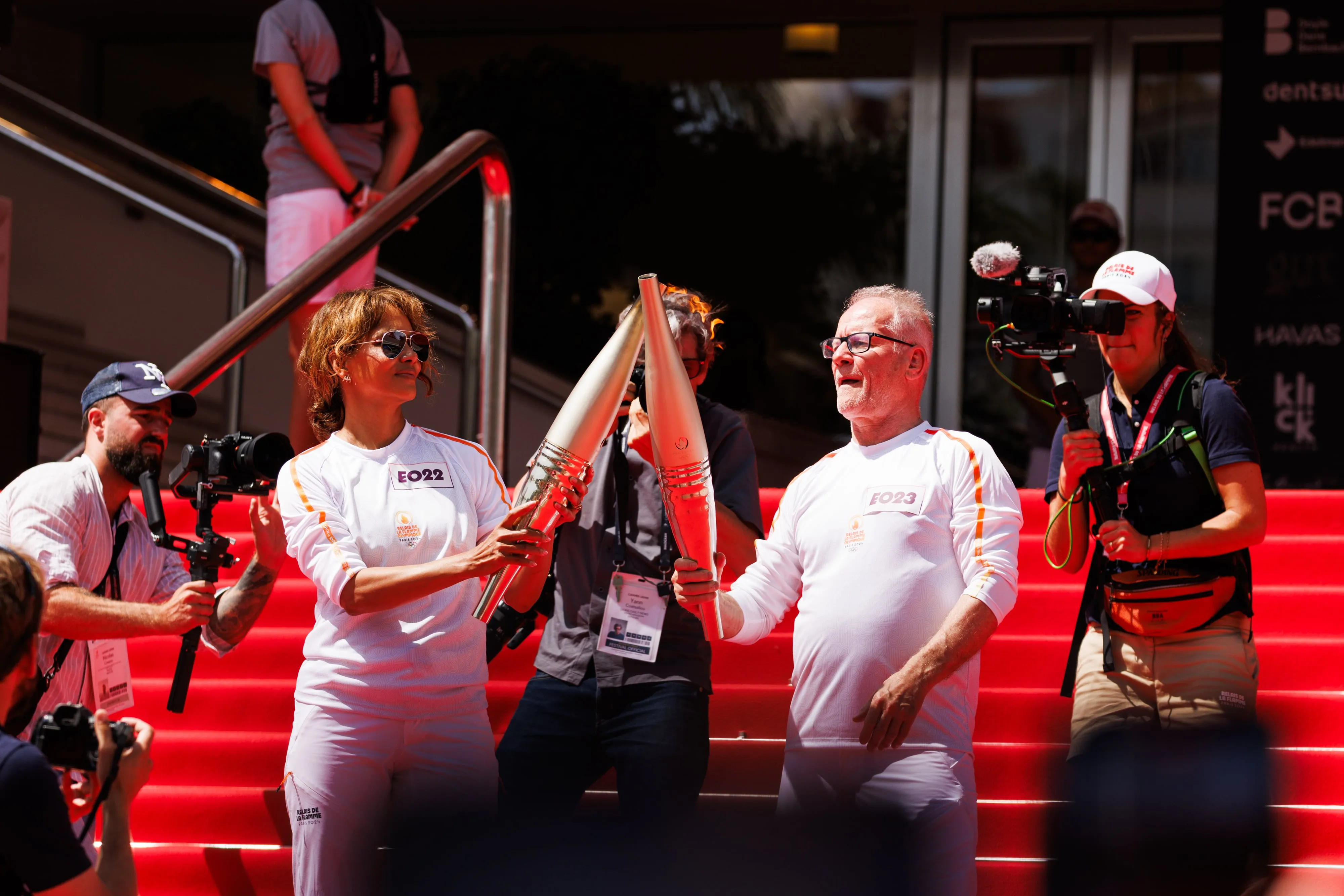 Actor Halle Berry and Thierry Fremaux carry the Olympic Torch in front of the Palais des Festivals