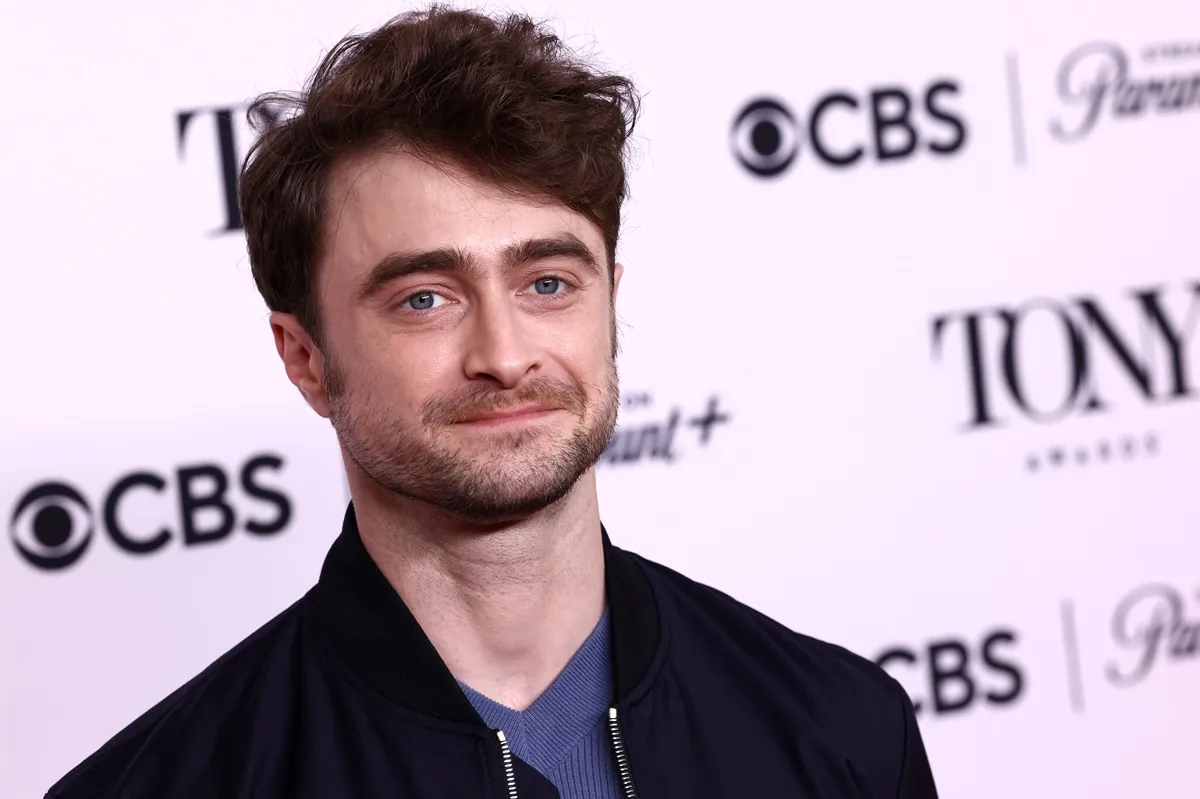 Daniel Radcliffe posing in a black jacket at Tony Awards Meet The Nominees Press Event.