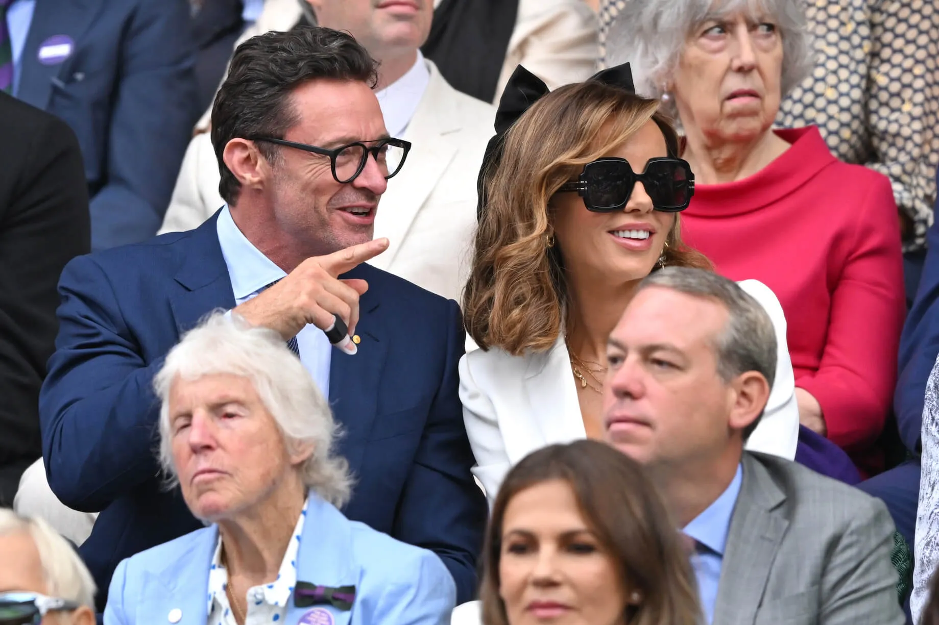 Hugh Jackman and Kate Beckinsale sitting next to each other and smiling at Wimbledon in 2024