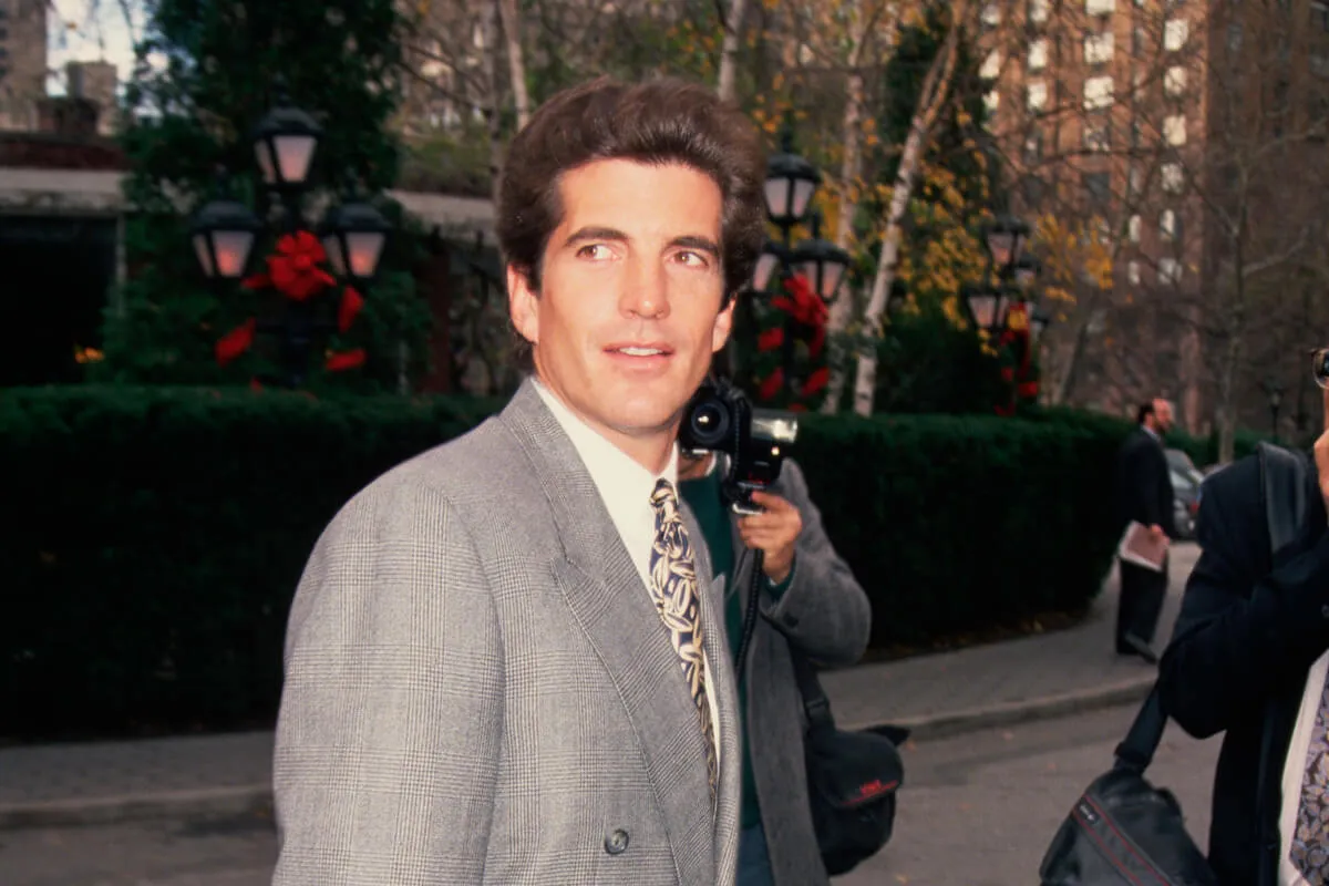 JFK Jr., who commented on Princess Diana's looks after a meeting, wears a gray suit.