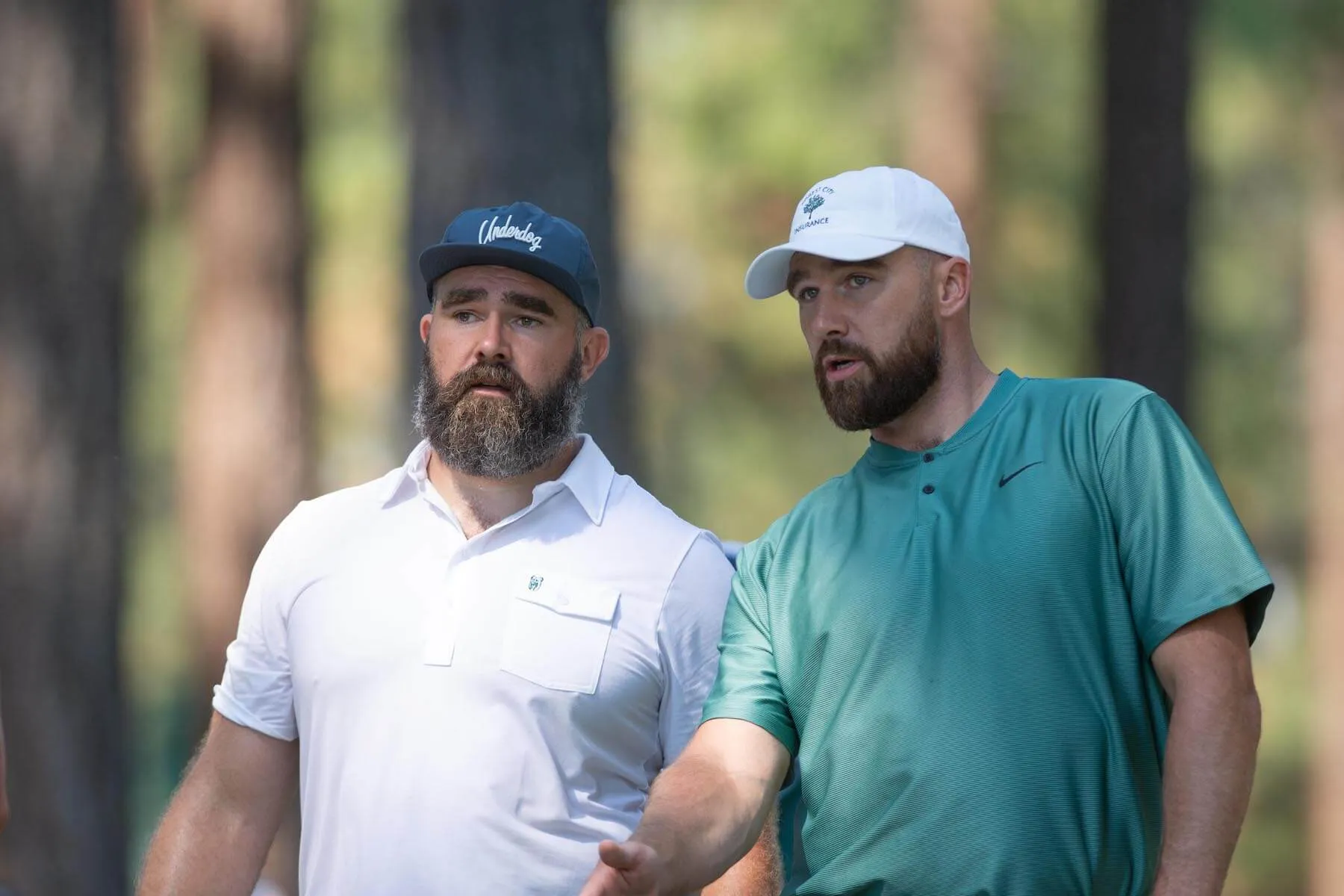 Jason Kelce and Travis Kelce standing next to each other and talking during the ACC Celebrity Golf Championship