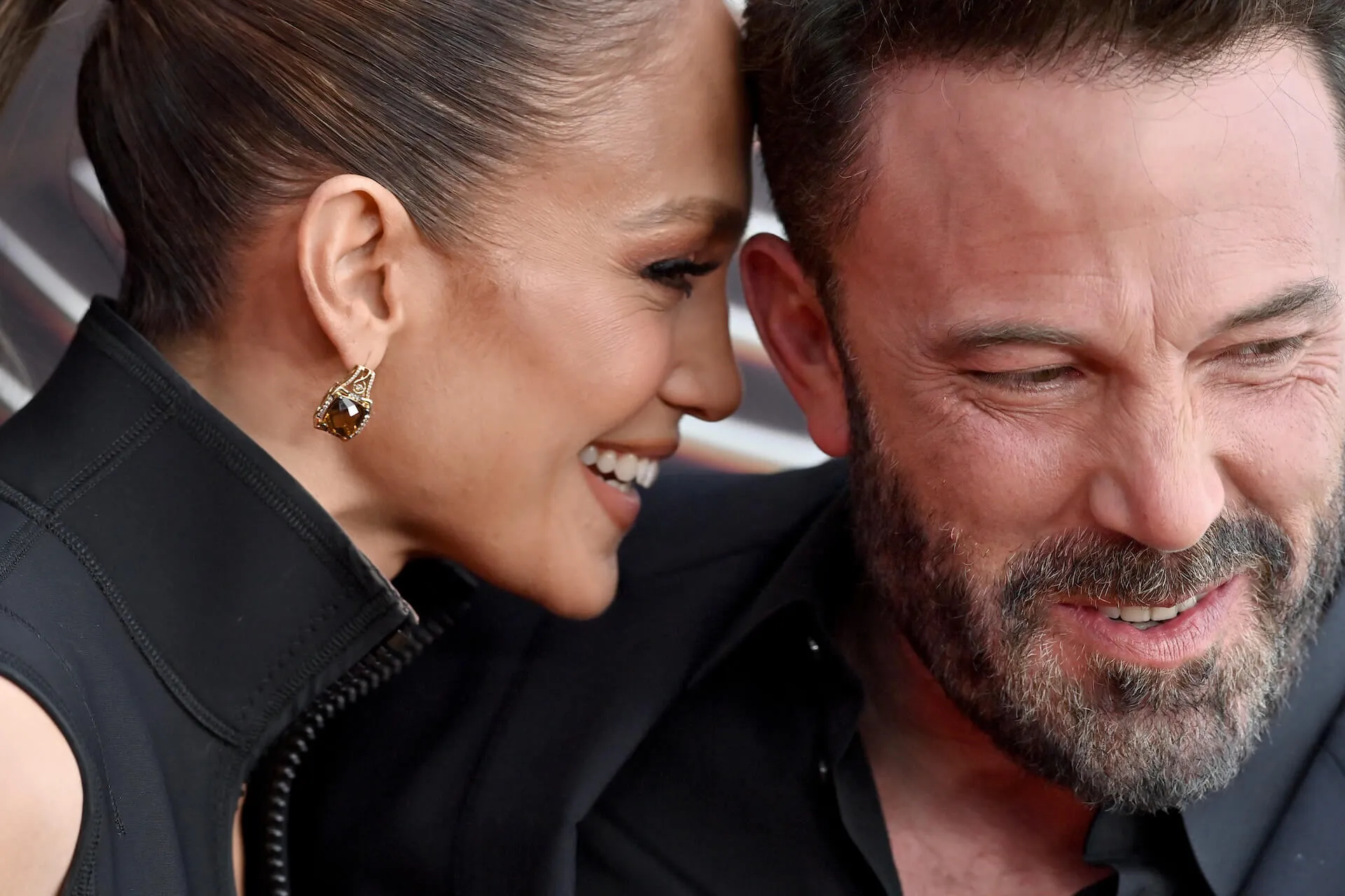 A close-up of Jennifer Lopez laughing into Ben Affleck's ear as he also laughs