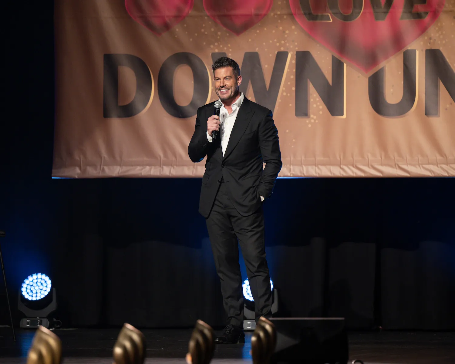 Jesse Palmer standing on stage with a microphone in 'The Bachelorette' Season 21 Episode 3