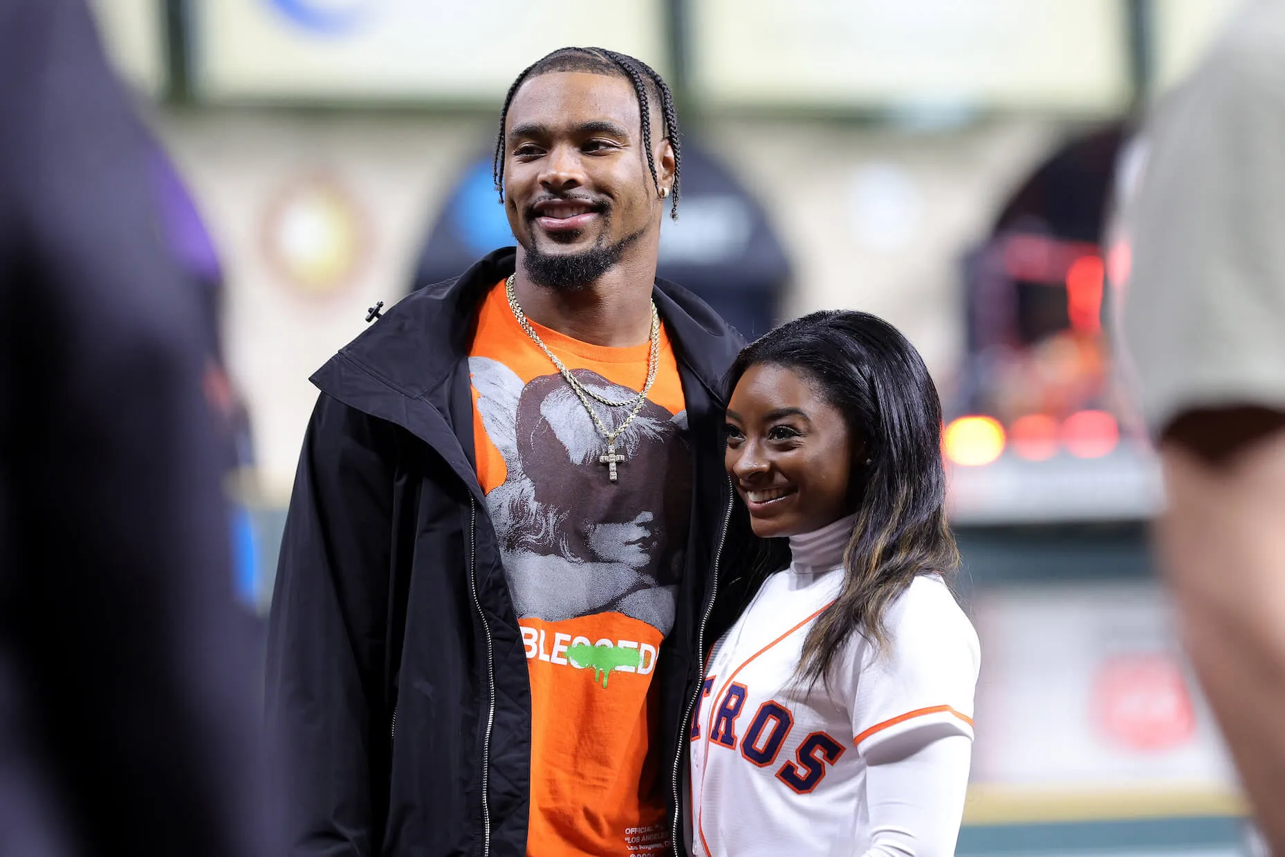 Simone Biles and Jonathan Owens pose on the field before Game 1 of the 2022 World Series